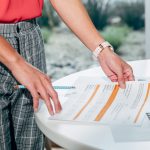 Woman in Red Holding Accounting Papers